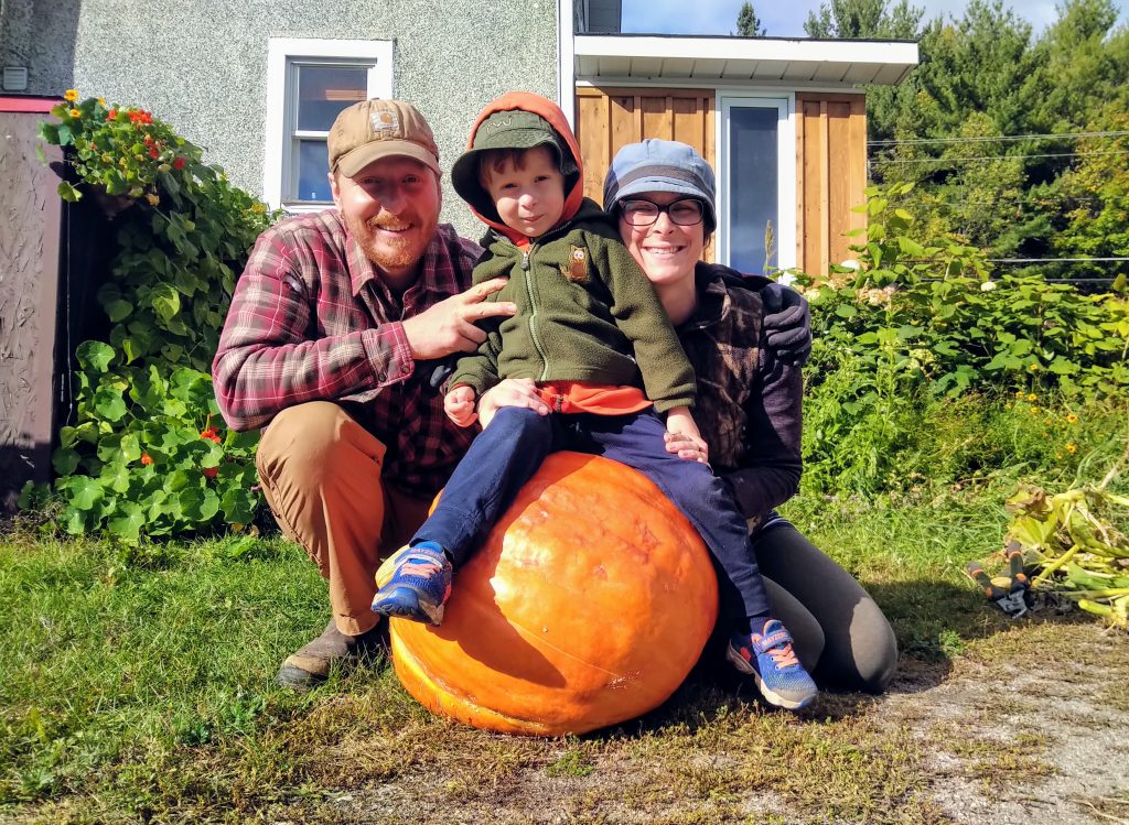 Homme, femme et enfant avec une citrouille.